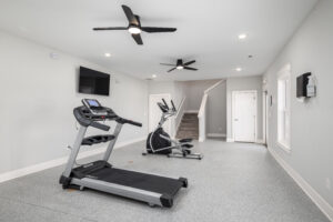 view of the workout room with exercise equipment and TV with stairs